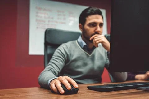  Focus on mans hand on computer mouse, blurred in the background man holdi... Stock-Fotos