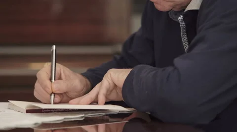 Focus on old man 's hand writing on notepad Vidéo 63418080