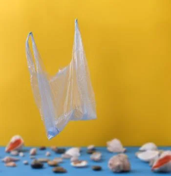 In focus is a plastic bag with a plastic bottle on a blurred background of sh Stock Photos