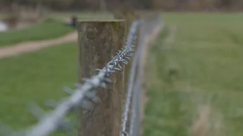 Focus pull along a barbed wire fence Stock Footage 122207376