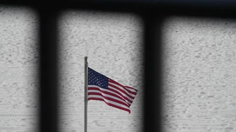 Focus Pull From Balcony Bars To An American Flag On the Beach Stockbeeldmateriaal 64454399