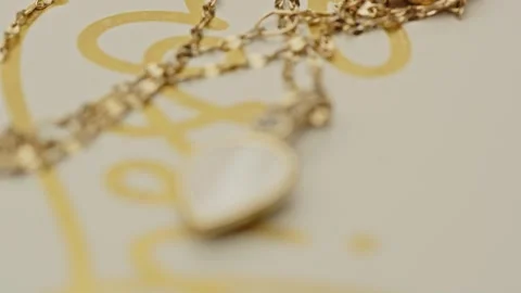 Focus pull to a beautiful locket decorated with diamonds on a golden chain Stock Footage 261790651