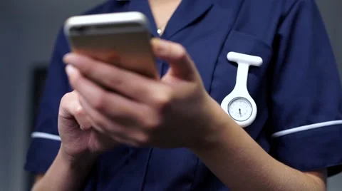 Focus pull between nurse watch fob and mobile cell phone Stock Footage 59087351