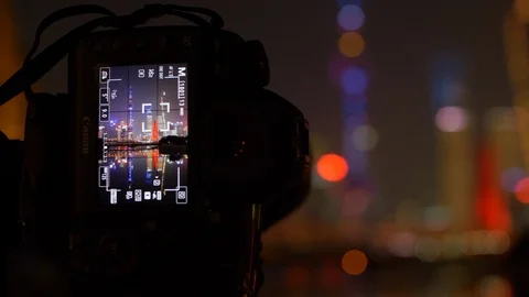 Focus Pull from Camera Screen Closeup to Lit Shanghai Skyline, Nighttime , 4k Stock Footage 123046311