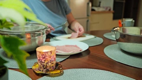Focus Pull From Candle To Woman Tenderizing Pork Cutlets In Slow Motion Stock Footage 340890417