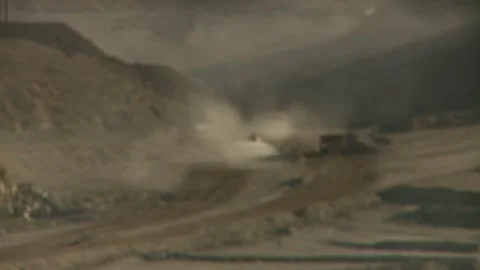 A focus pull of construction vehicles driving on an opencast mine Stock Footage 312400371