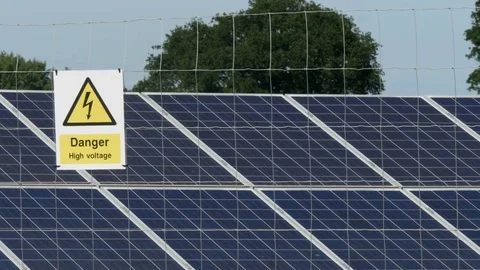 Focus pull to danger sign at solar electricity farm Stock Footage 77346315