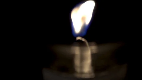 Focus pull to flickering candle flame in glass jar. Stock Footage 129808377