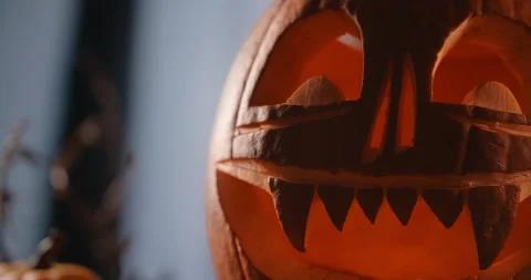 Focus pull to the halloween pumpkin face with candles in it stands in dark windy Stock Footage 164554861