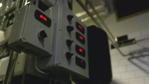 Focus pull to an industrial grey panel with control knobs and blinking red 動画素材 104363491