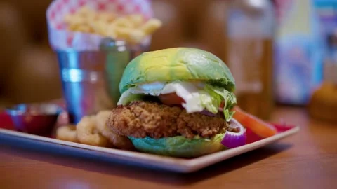 Focus Pull From Leather Seat To Abstract Green Chicken Burger In UK Pub Video stock 237694225