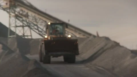Focus pull of a loader driving down a mound on an opencast mine Stock Footage 312400490