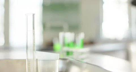 Focus pull is moving from left to test-tube rack, revealing bright green Stock Footage 340969046