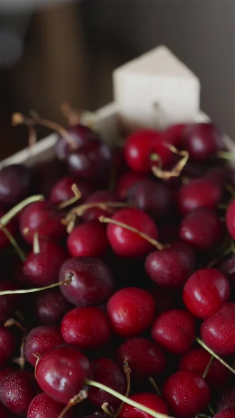 Focus pull to a rustic wooden box full of sweet cherries vertical Stock Footage 338395374