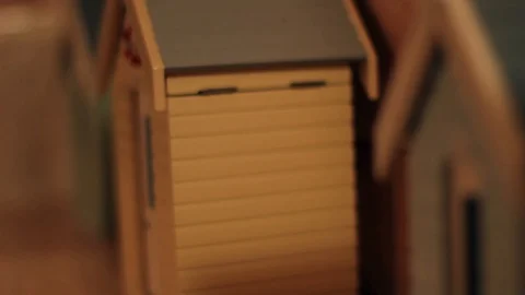 Focus Pull on Three Small Model Scale Wooden Beach Huts on Shelf Vídeo Stock 94489174
