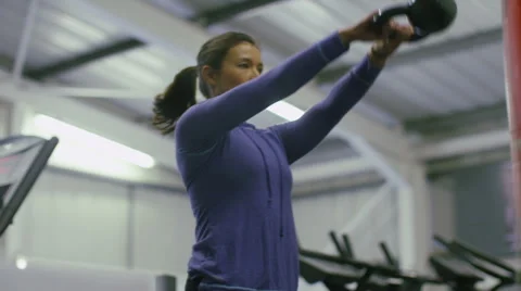 Focus pull from weight to young woman exercising with a kettle bell 库存影片 47969909