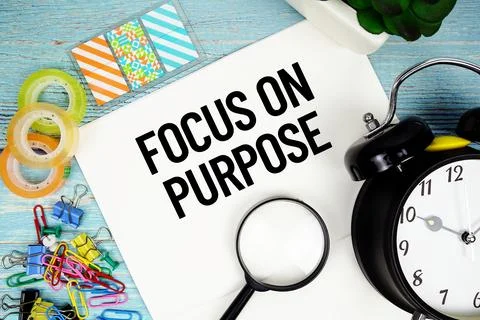 Focus On Purpose text on a paper surrounded by office supplies, a magnifyin.. Stock Photos