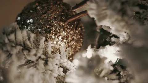 Focus rack to a close up macro shot of a gold ornament on a snow frosted Stock Footage 226146548