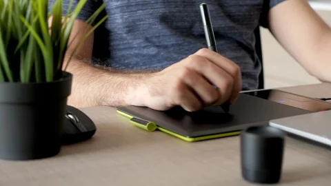 Focus rack on designer working on a digital tablet known as digitiser Stock Footage 93304164