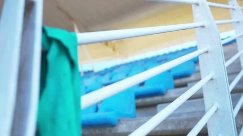 Focus Rack From Empty Stadium Seating to Green Cloth Draped Over Railing Stock Footage 346654021