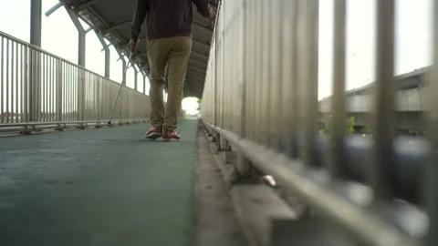 Focus of rear view of young blind man walking step along the flyover with a whit Stock Footage 276485211