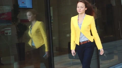 Focus on the reflection. Slow motion. Young business woman in yellow jacket Stock Footage 65406081