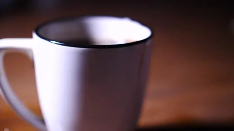 Focus to the rim of a mug of coffee with liquid spillage Stock Footage 153667188