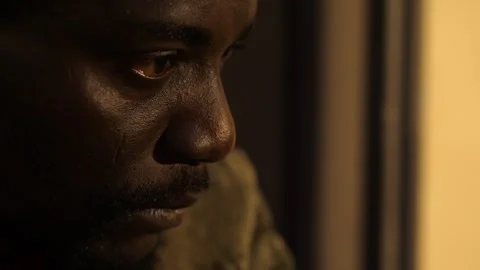 Focus on sad depressed gaze of young black migrant in the dark Stock Footage 240329348
