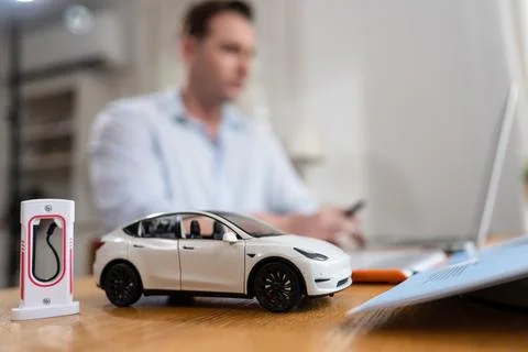 Focus scale EV car and charging station mockup model. Synchronos Foto stock