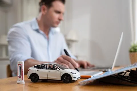 Focus scale EV car and charging station mockup model. Synchronos Stock Photos