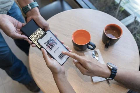 Focus on Scan here to pay text. Close up of hands Scaning QR code for digit.. Stock Photos