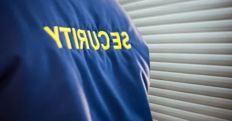 Focus on a security guard jacket near the blind Stock Photos