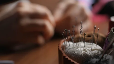 Focus sewing accessories in the box. The defocus hands of a young woman sewin Video stock 128363603