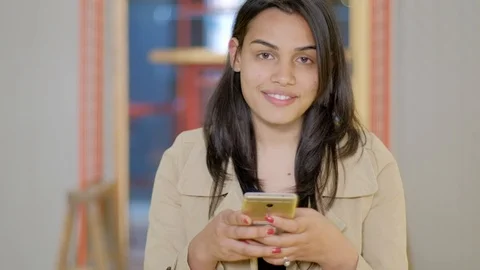 Focus shift to an attractive Indian young woman smiling to the camera as she is  Stock Footage 102423216