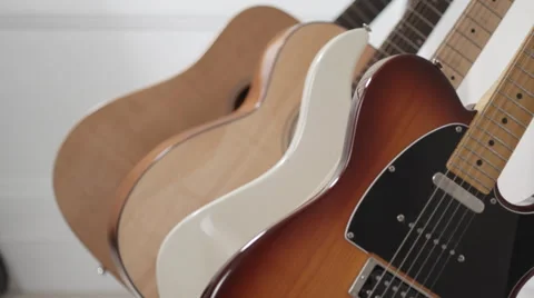 Focus Shifting through various guitars on an instrument rack Stock Footage 50245429