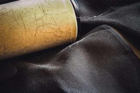 Focus stack of a lint roller resting on a dark suit jacket to remove pet animal Stock Photos