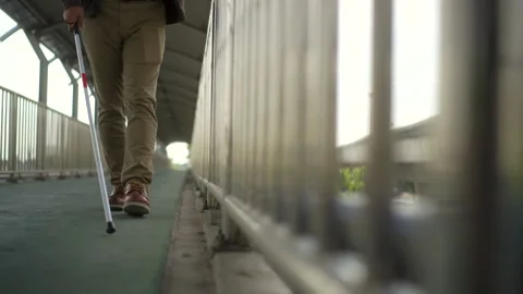 Focus of the step of young blind man walking step along the flyover with a white Stock Footage 276484937