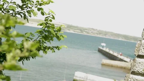 Focus switch from leaves to harbour pier 스톡 동영상 137233052