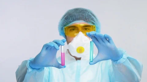 Focus on test tubes with pink and blue liquid in the arm of fully protected Stock Footage 127036664