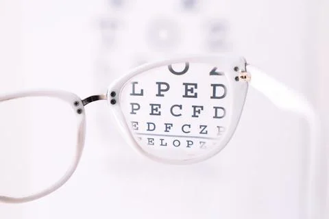 Focus through white frame glasses on Snellen chart close up Foto stock