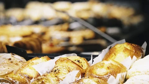 Focus transition: delicious muffins and croissants are on the counter in a pa Stock Footage 117101444