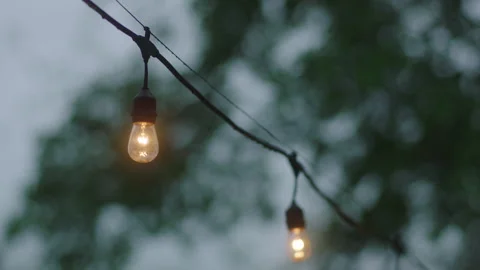 Focus in on two bulbs from string light backyard decorations Vídeos de archivo 251225455
