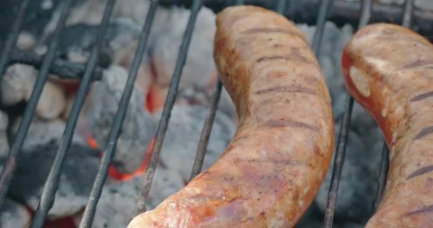 Focus on two sausage links on a bbq Stock Footage 286902572
