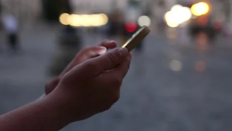 Focus on a woman's hand using a smartphone, a night city street full of neon lig Stock Footage 202245670