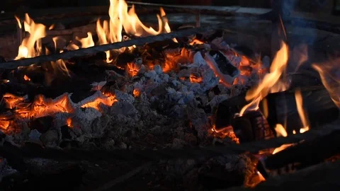 Focus of wood burning inside a fireplace. Fire playing around burned wood 動画素材 123010207