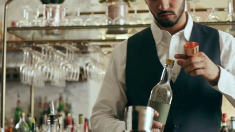 Focus young bearded mixologist adding ingredients into shaker making classic Dai Stock Footage 199456860