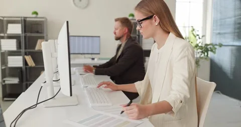 Focused accountant woman working at computer with dual monitors in modern office Stock Footage 343249766