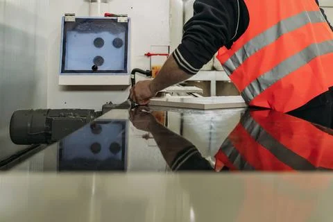 Focused activity unfolds in an industrial workshop as a skilled worker, clad  Stock Photos