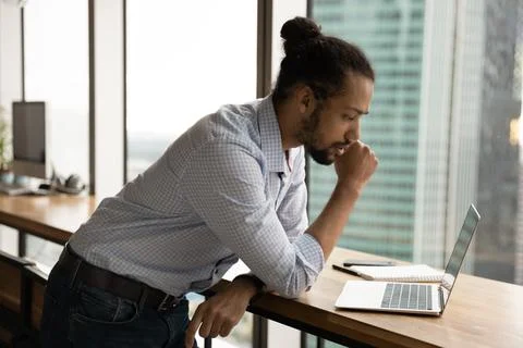 Focused African businessman working using computer thinking of problem solution Foto stock