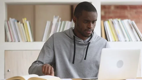 Focused african student study online on computer make notes Stock Footage